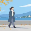 秋の屋外でコートを着て、肌寒さに合わせて服装を調整する様子
