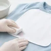 衣類のゼッケン付近の色移りを白い布でやさしく処理する様子