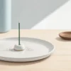 安定した陶磁器の香皿と香立てに立てたスティック香