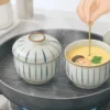 鍋で茶碗蒸しを弱く再加熱し竹串で固まり具合を確認する様子