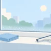 朝の窓に出た結露と、拭き取り用の布やワイパーがある暮らしの風景