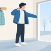 涼しい日に玄関でダウンジャケットを着る様子