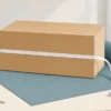 大きな箱を包装紙の上で採寸するイラスト